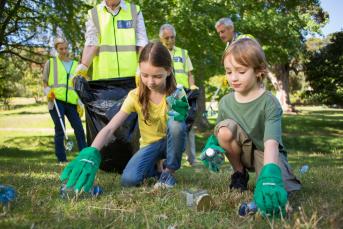 Kinder und Erwachsene sammeln Müll auf
